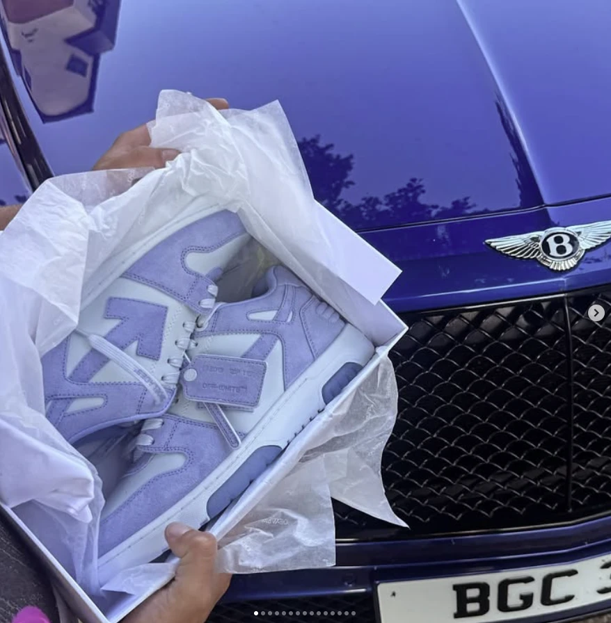 Off-White Out Of Office trainers in lilac suede, held over a car bonnet